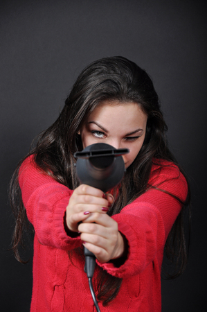 Girl with a hair dryer in handsの写真素材