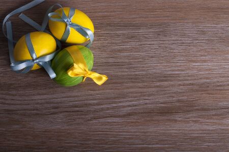 Yellow and green eggs on a wooden backgroundの写真素材