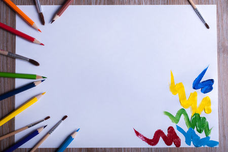 Colored pencils and brushes on white paperの写真素材