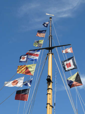 Colored flags on a pole in front of a blue skyの写真素材