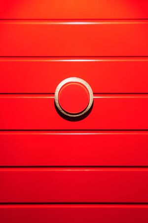 Detail of a red painted door with a stainless steel ring の写真素材