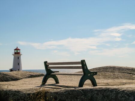 Bench with lighthouse at Peggys Cove, Nova Scotia with View onto the sea.の写真素材
