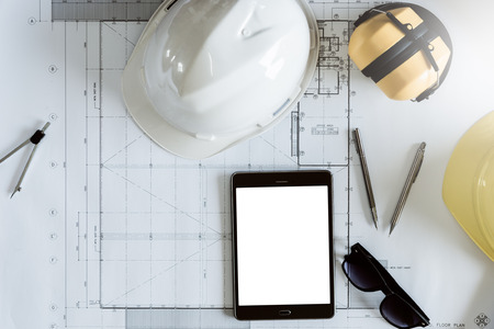 Desk of engineering in the workplace morning time, Engineering tools and the tablet with construction drawing background, Top view from above with clipping path included the photo.の写真素材