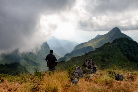 Viewing and capturing photo of sunlight at mountains and sky with mist in foggy weather at Doi Luang chiang Dao on chiang mai in Thailand.の写真素材