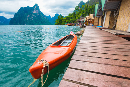 Red canoe floating on the asia lake and homestay in the among the islands with mountains in...