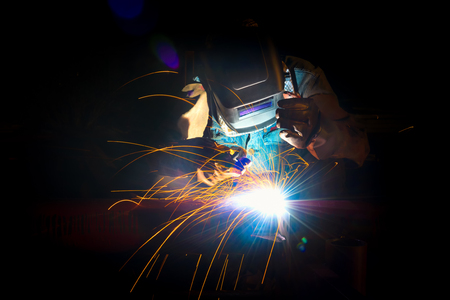 Welding at the industrial factory for steel production heavy industrial. add grain filter dark tone...