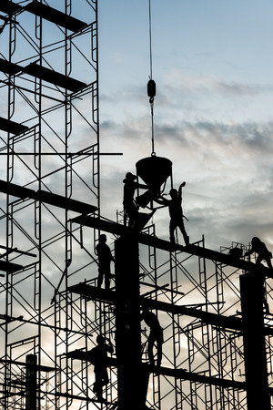 Silhouette of worker. Construction Building casting concrete work on scaffolding.の写真素材