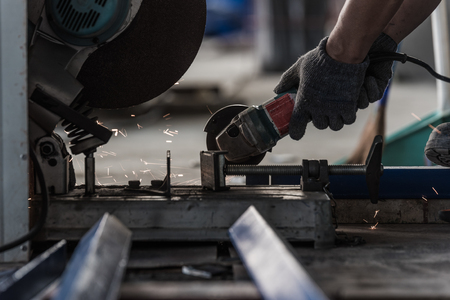 Hand of worker holding a grinding machine in factoryの写真素材