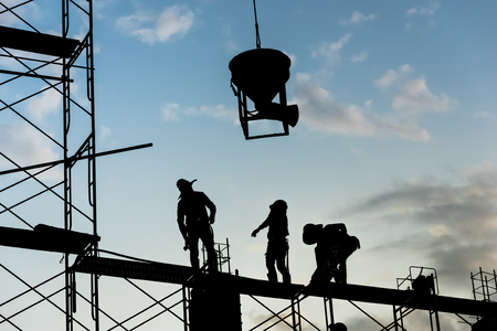 Silhouette of worker. Construction Building casting concrete work on scaffolding.の写真素材