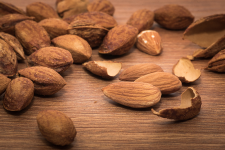 almonds roasted butter in heap on wooden tableの写真素材
