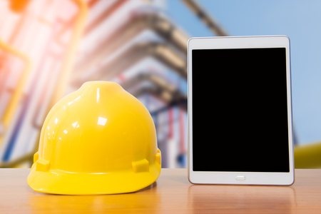 The yellow hard hat of engineer or technician with a tablet of communication for industrial control. Clipping path included the photo.の写真素材