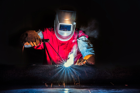 Welder-Worker welding and cutting steel in workshop of construction site with Oxy-Propane cutting...