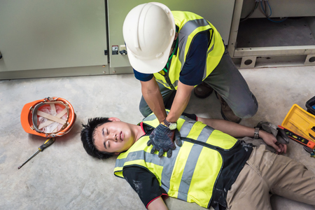 Start Compressions using both hands - 30 times, Life-saving and rescue methods. Accident at work of electrician job or Maintenance worker in the control room of factory.の素材 [FY310123504174]