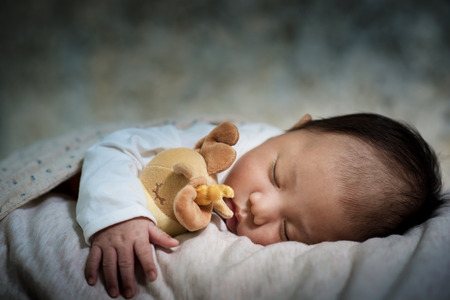 Newborn baby boy sleeping sweetly on the stomach.