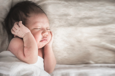 Newborn baby boy sleeping on its side with copy space.の写真素材