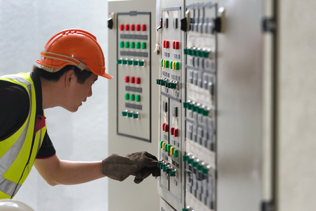 Electrician young people looking the panel of Main Distribution Board in the control room of plant.の素材 [FY310123504972]