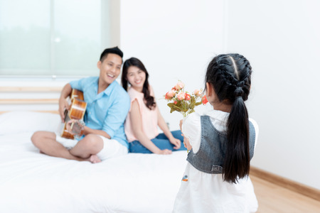 Asian people, Happy family in bedroom at home. Mother, Father and the children playing, Activities of family members are good family health of three people Education of kids, Health Insurance concept.の写真素材