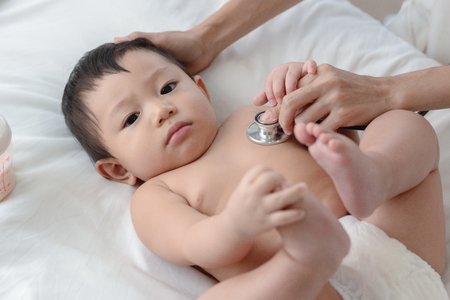 Pediatrics doctor examining heartbeat and lungs of little baby boy with instruments stethoscope, Health care, Baby, Baby regular health check-up conceptの写真素材