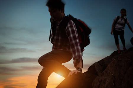 Hiking of Asian couple standing on the mountain, Rock mountain hiking challenge, Concept of limits of life and Hiking successful. Add motion blur filter for movement filling.の写真素材
