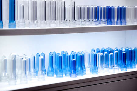 Sample of Plastic Bottle Part from PET Preform Injection Molding Machine on Shelves, Polyethylene Terephthalate, PET  Preforms, Standard of containers production and  food-grade raw conceptの写真素材