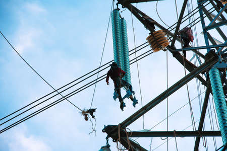 Worker wiring on electric power transmission infrastructure. Electric construction and maintenance...