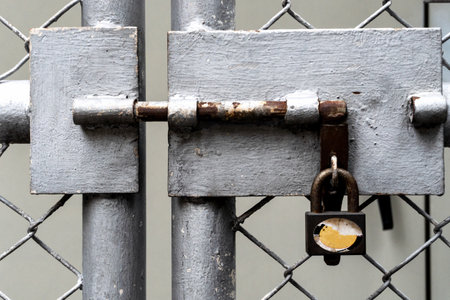 Close-up old padlock gate of chain-link steel fence.の写真素材