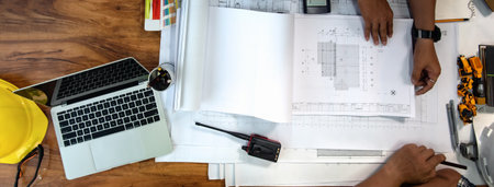 Top view of Desk of Architecture and Engineer Designer planning with blueprint on desk in office....