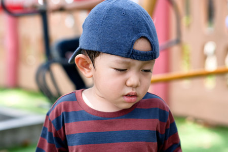 Asian little boy portrait tired expression in the Park on the Playground for Kids & Childrenの写真素材