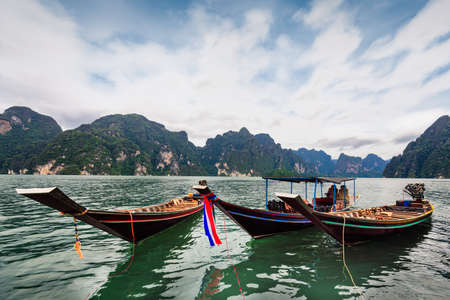 Long-tailed boat group floating on the asia lake in the among the islands with mountains in...