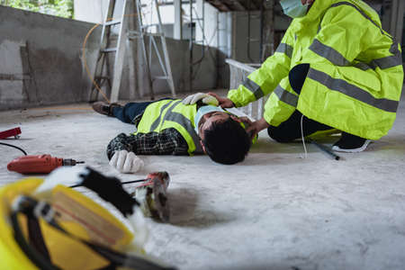 Work accidents of worker in the workplace at construction site area, Builder accident falls ladder on floor and Unconscious, Electric suction, Unsafe concept.の写真素材