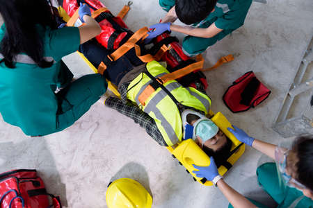 First aid for injuries in work accidents. Using first aid equipment support to loss of feeling or loss of normal movement and Loss of function in limbs, First aid training to transfer patient.の写真素材