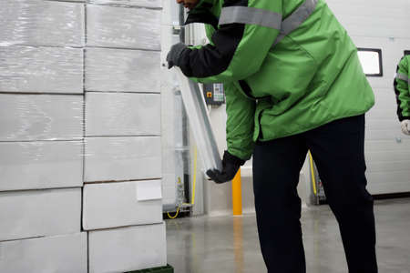 Plastic wrapper roll to packaging in loading goods of the freezing warehouse., Storage for Coronavirus Vaccine in cold room., Export-Import Logistics system concept. Focus shooting on package box.の写真素材