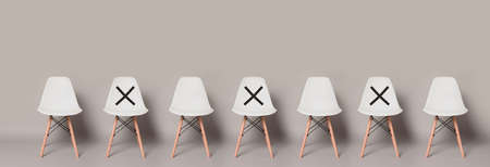 Empty Modern White Chair Standing Row with Symbol on Chair to Keep Your Distancing on Light Gray Colour Banner Size Background with copy space.の写真素材