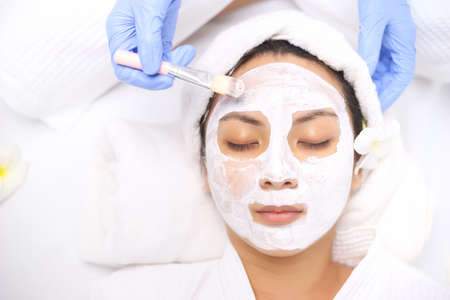 Young Asian Women getting facial care, Facial masks, and spa beauty treatment for soft smooth silky...