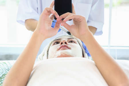 Young Asian Women getting facial care, Facial masks, and spa beauty treatment for soft smooth silky...