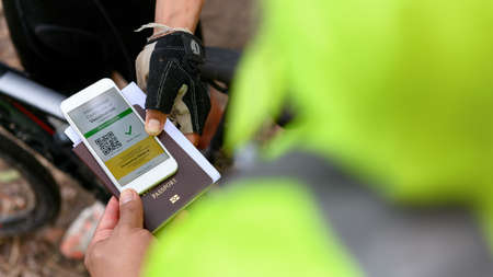 Disease immunity passport, Athlete uses application on smartphone show an international...