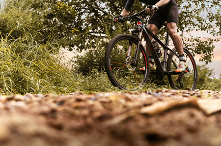 Mountain biking, Cyclist ride training on MTB track in forest with mountain bike, Outdoor sport activity fun and enjoy riding. Basic techniques of athlete. Selection focus on cyclist legsの写真素材