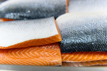 Fresh salmon fillet close-up after cutting or slicing in the cold room factory. Selection focusing on salmon fillet with Soft focusing shooting.の写真素材