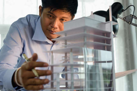 Architects worked thinking design architecture with building model, Design from his idea stationery on desk office. Startup and analysis of the architecture of building structure.の写真素材