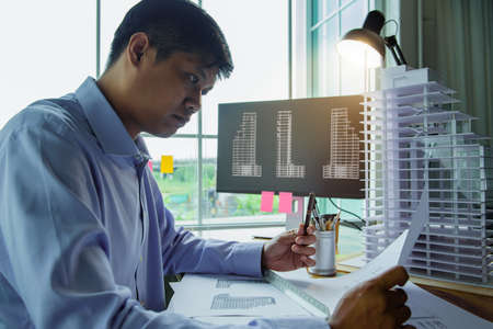 Architects worked thinking design architecture with building model, Design from his idea stationery on desk office. Startup and analysis of the architecture of building structure.の写真素材