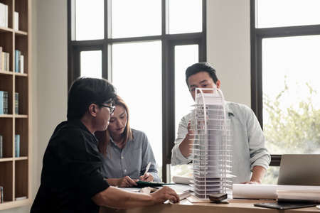 Heads of each department meeting together between Construction Engineers or Architect and Sales. Brainstorm management an idea to find a way to deal with construction and communication for sales.の写真素材