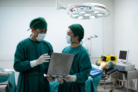 Doctors or surgeons with Physician assistant standing to discussion about a patient case in an operating room before performing difficult operations, Surgery on patient that requires knowledge.の写真素材