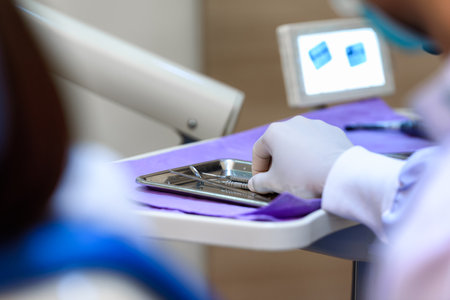 Dentists hand wearing gloves holding dental tools in dental clinic. Dental tools and equipment concept.の写真素材