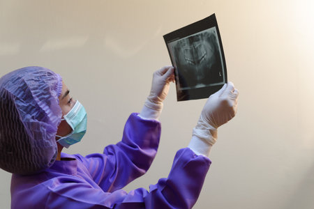Dentist woman holding to show orthodontist x-ray picture in dentist's office. Focusing on  x-ray...