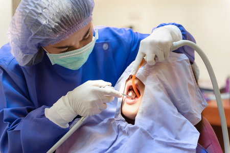 Dentist treatment teeth cavity with Patient while holding air water syringe machine at dental clinic office, Professional treatment at dental clinic and teeth care.の写真素材