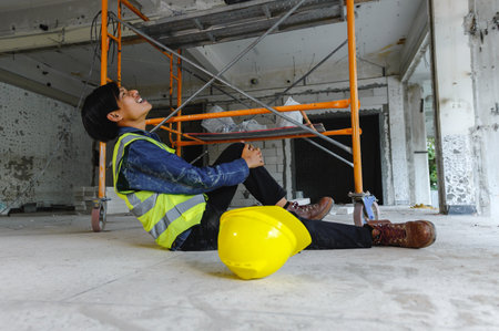 Knee accident at work of construction worker at site. Builder accident falls scaffolding on floor,...