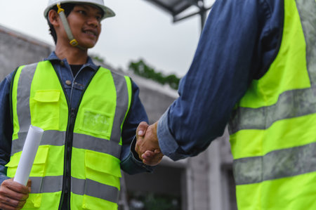 Close-up hand of Civil Engineer with contractor partners are shaking their hands in construction building, agreement of partners in contract. Handshake of civil engineer business concept.の写真素材