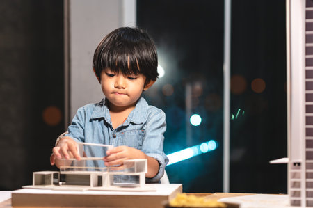 Inspiration kids in occupation in the future, Asian kid playing and concentrating to home model box in the job of parent at office room at night. Skill and learning practice of children's success.の写真素材