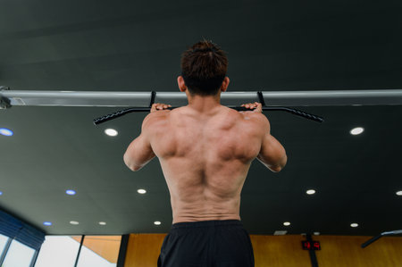 Muscular man, Bodybuilder man standing prepares workout with pull-up station bar, Body weight vertical pull-up in the gym. Fitness exercise building muscle concept.の写真素材
