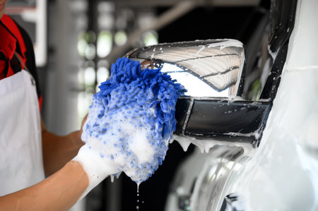 Man Worker use Soap Washing and Taking Care of Vehicle car body with Diligence, Car Washing and Detailing to Shiny and Clean Vehicles for Automotive Maintenance.の写真素材